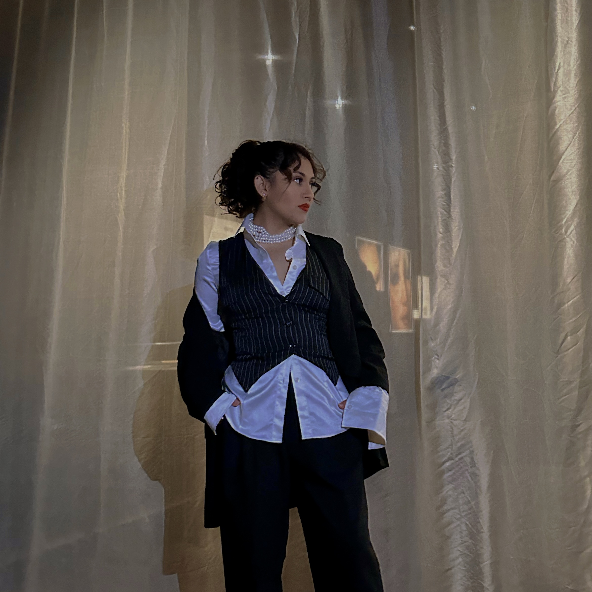 Andrea en costume, chemise et collier de perles